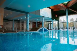 a large swimming pool in a hotel with blue ceilings at SPA Hotel Olymp in Velingrad +129 photos