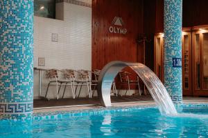 a swimming pool with a water fountain in a hotel at SPA Hotel Olymp in Velingrad