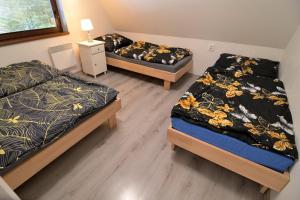 a bedroom with two beds and a night stand with a lamp at Andrea Chata in Štrba
