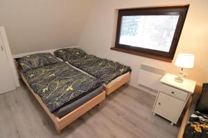 a small bedroom with a bed and a window at Andrea Chata in Štrba +2 photos