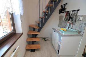 a kitchen with a sink and stairs in a room at Andrea Chata in Štrba