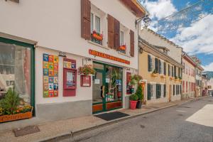 a street with shops and buildings in a town at Hôtel du Centre in Villard-de-Lans