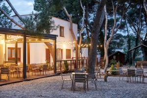 a patio with chairs and tables and a building at Camping Taiga Lake Caspe - Maeva Vacansoleil in Caspe