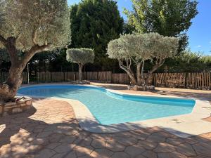 a swimming pool with trees in a yard at Camping Taiga Lake Caspe - Maeva Vacansoleil in Caspe