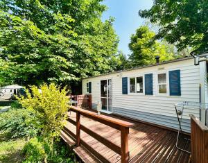 a house with a deck and a house at Camping L'Amandier in Gigors