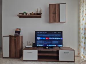 a flat screen tv sitting on top of a table at Noémi Wellness Apartman in Siófok