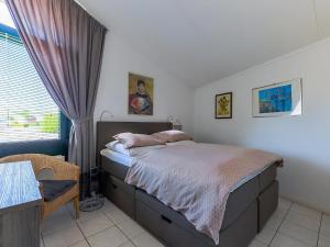 a bedroom with a bed and a table and a window at Aquaronde 110 in Lemmer