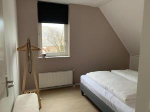 a small bedroom with a bed and a window at Park De Marol Grutto 8 in Lemmer