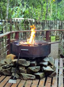 a grill with a fire in it on a pile of rocks at ANAVÁ Lodge de Selva y Piscina privada in El Soberbio