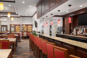 a restaurant with tables and chairs and a bar at DoubleTree by Hilton Cincinnati Airport in Hebron