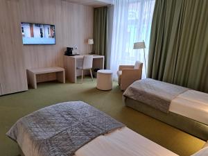 a hotel room with two beds and a desk at Hotel Armatti in Braşov