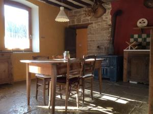 a kitchen with a wooden table and chairs at Le RepAire de La SalAmandre in Ivrey
