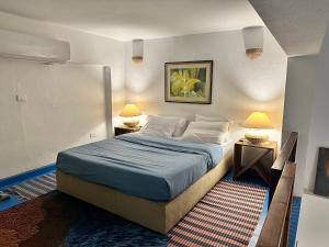 a bedroom with a bed with blue sheets and two lamps at Amnesia Residence in Naama Bay - Downtown in Sharm El Sheikh