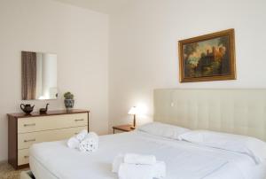 a bedroom with two beds with white sheets and towels at Tana del Manzoni in Barzio