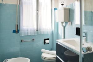 a blue bathroom with a toilet and a sink at Tana del Manzoni in Barzio +36 photos
