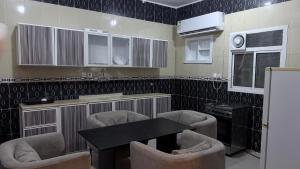 a kitchen with chairs and a table and a counter at شقق عناوين الفخامة in Şāmitah