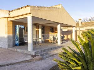 a building with a patio with tables and chairs at Winahost Villa Unión in Puebla de Vallbona