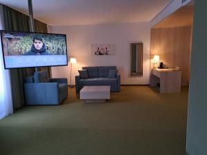 a living room with a couch and a flat screen tv at Hotel Armatti in Braşov