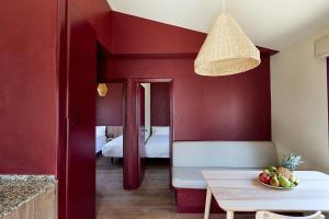 a room with red walls and a table with a bowl of fruit at Camping Taiga Lake Caspe - Maeva Vacansoleil in Caspe