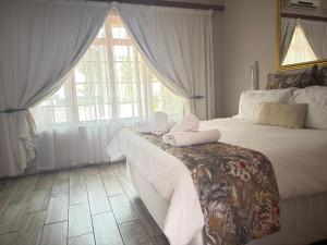 a bedroom with a bed with towels on it at Marico Bosveld Guesthouse in Zeerust