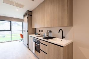 a kitchen with wooden cabinets and a sink at For Students Only Space St Andrews in St. Andrews