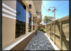 a corridor of a building with a sidewalk at Rustic Retreat Three Bedroom House in Pagdalagan