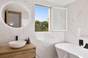 a white bathroom with a sink and a mirror at Villa Sa Sirvi in Santa Ponsa +18 photos