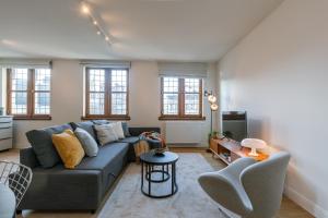 a living room with a couch and a table at Bright Duplex near Antwerp Cathedral in Antwerp