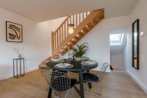 a dining room with a table and chairs and a staircase at Bright Duplex near Antwerp Cathedral in Antwerp +25 photos