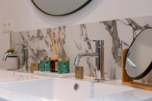 a bathroom with a white sink and a mirror at Bright Duplex near Antwerp Cathedral in Antwerp