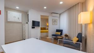 a living room with a table and chairs in a room at Sítio do Castelo Beach in Cascais by LovelyStay in Cascais