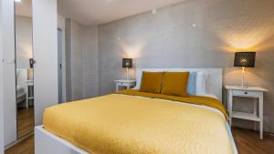 a bedroom with a large yellow bed with two lamps at Sítio do Castelo Beach in Cascais by LovelyStay in Cascais +18 photos