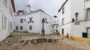 an alley in a city with white buildings at Sítio do Castelo Beach in Cascais by LovelyStay in Cascais