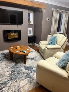 a living room with two couches and a coffee table at Greenways House in Lancaster