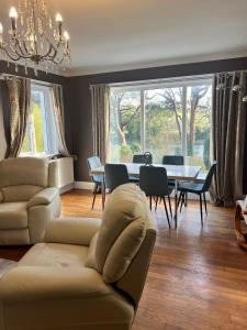 a living room with a couch and a table with chairs at Greenways House in Lancaster