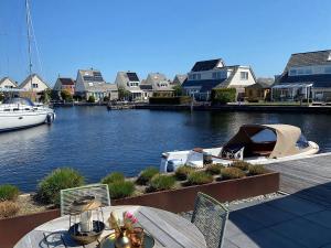 a table and chairs with a boat in the water at Aquaronde 073 in Lemmer