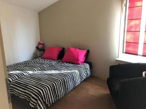 a bed with two pink pillows in a room at Aquaronde 073 in Lemmer