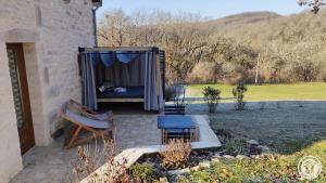 a bed in a shed with a table and a bench at L'écrin de lacoste in Chasteaux +3 photos