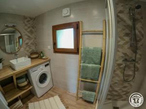a bathroom with a shower and a washing machine at L'écrin de lacoste in Chasteaux
