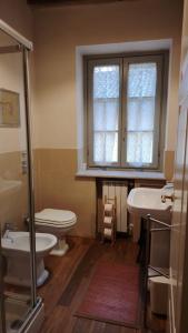 a bathroom with a toilet and a sink and a window at Bed and Breakfast Locanda Lugagnano in Cassinetta di Lugagnano +27 photos