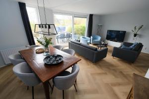 a living room with a wooden table and chairs at Park Brekkense Wiel 103 in Lemmer