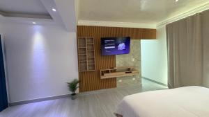a bedroom with a flat screen tv on a wall at Hotel Juan Dolio in Juan Dolio