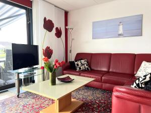 a living room with a red couch and a table at Park Brekkense Wiel 037 in Lemmer