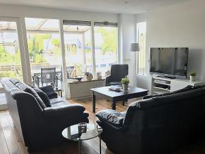 a living room with two couches and a flat screen tv at Park De Markol River House in Lemmer