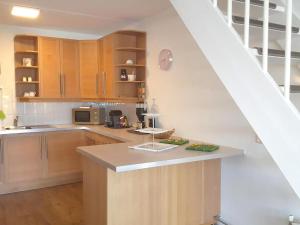 a kitchen with wooden cabinets and a counter top at Park De Markol River House in Lemmer