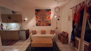 a kitchen with a table and a painting on the wall at Syros Mandala Studio in Ano Syros +15 photos