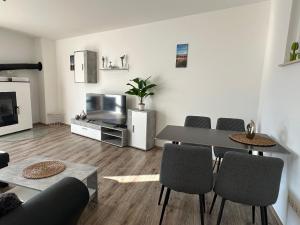 a living room with a table and chairs and a television at Ferienhaus Weimarer Land in Berlstedt