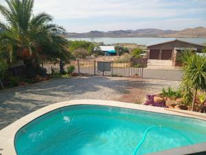 a swimming pool with a view of the water at OppiDam Gastehuis in Vanderkloof