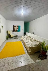 a bedroom with a bed and a yellow rug at Cantinho do Sol in Recife