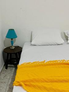 a bed with a blue lamp on a side table at Cantinho do Sol in Recife